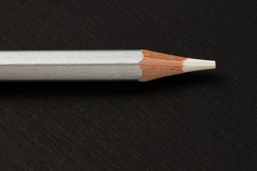 sharpened colored pencils in a silver shirt,on a black paper background
