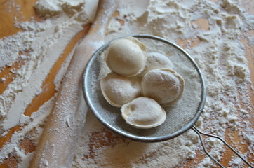 making homemade dumplings with your hands. The table is in flour.