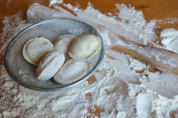 making homemade dumplings with your hands. The table is in flour.