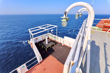 Ship structures, masts, antennas, funnel, ship wheelhouse against the blue sky and clouds. Vessel traveling at ocean. © masterskuz55