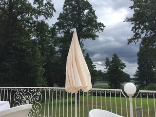 closed parasol under trees and stormy sky © piquenique