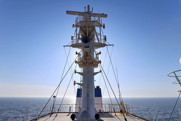Ship structures, masts, antennas, funnel, ship wheelhouse against the blue sky and clouds. Vessel traveling at ocean. © masterskuz55
