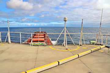 Ship structures, masts, antennas, funnel, ship wheelhouse against the blue sky and clouds. Vessel traveling at ocean. © masterskuz55