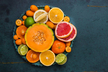 Flat lay layout of fruit citrus and other sommer fruits on green background