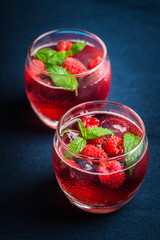 Raspberry and mint cocktail in glass on the rustic background. Selective focus. Shallow depth of...