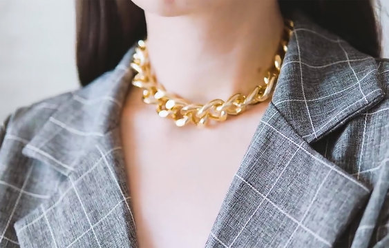 Elegant Woman With Gold Necklace And Gray Plaid Blazer