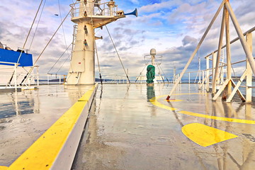 Ship structures, masts, antennas, funnel, ship wheelhouse against the blue sky and clouds. Vessel traveling at ocean. © masterskuz55