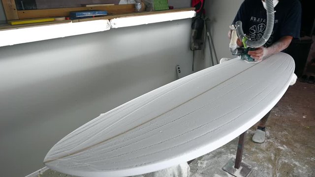 Surfboard Modeling Workshop - Man shaping a surfboard with a sander