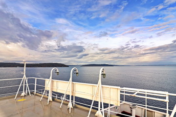 Ship structures, masts, antennas, funnel, ship wheelhouse against the blue sky and clouds. Vessel traveling at ocean. © masterskuz55