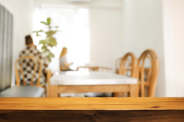 coffee shop blurred background with empty wooden desk montage.