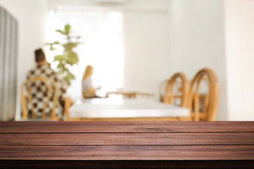 coffee shop blurred background with empty wooden desk montage.