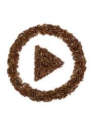 Play sign made from grains of brown rice on an isolated white background.
