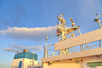 Ship structures, masts, antennas, funnel, ship wheelhouse against the blue sky and clouds. Vessel...
