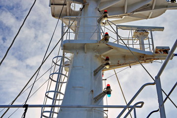 Ship structures, masts, antennas, funnel, ship wheelhouse against the blue sky and clouds. Vessel traveling at ocean. © masterskuz55