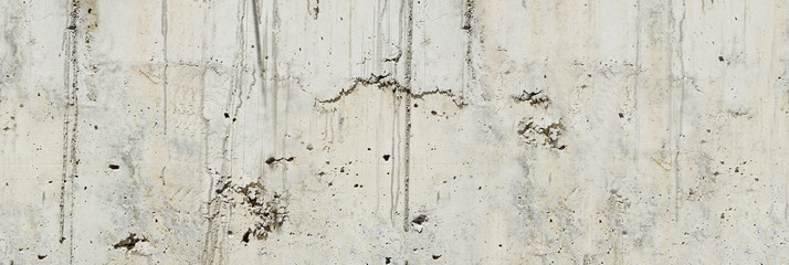 Concrete wall. Weathered old paints on the spilled wall.