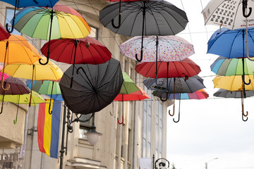 A single black umbrella dropped from all the umbrellas above next to it