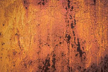 The old iron background is painted yellow, orange, purple, red in with rust and chips