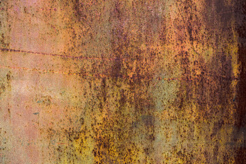 The old iron background is painted yellow, orange, purple, red in with rust and chips