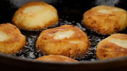 fried cottage cheese cakes on pan, close up