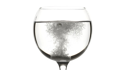 pill of effervescent aspirin in elegant glass with water, white background