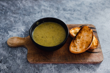 plant-based food, vegan pesto and zucchini soup with toasted bread