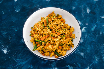 plant-based food, vegan tofu scramble with mixed vegetables including carrots green beans and peas