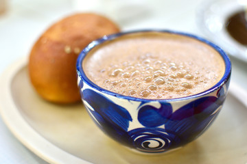 bebida de chocolate tradicional oaxaquelo en taza azul acomañada con pan