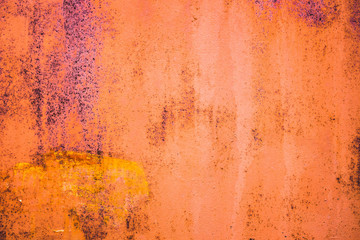 The old iron background is painted yellow, orange, purple, red in with rust and chips