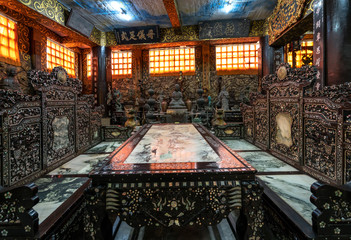 Obraz premium The wooden worshiping cabinet with meticulous pearls is displayed in old furniture market near temple in Da Lat, Vietnam.