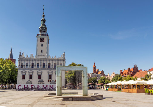 Chelmno, Poland - August 12, 2020: Main square in old town on a summer day. There is a fountain in the center and old city hall on the left