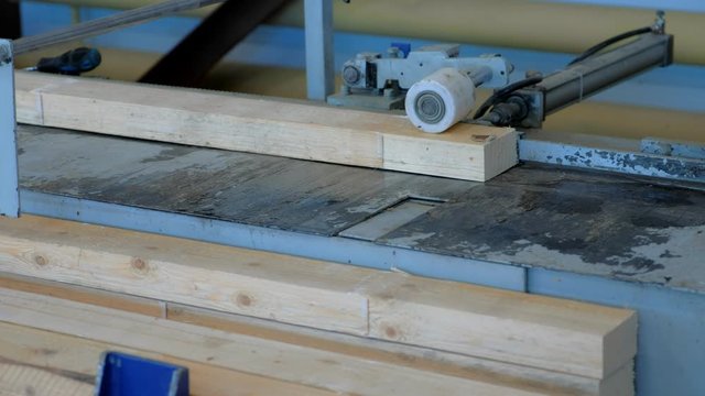 Production of laminated veneer lumber on plant on cutting machine equipment. The production line for timber. Woodworking timber industry: machinery and equipment for press and cutting of lumber.