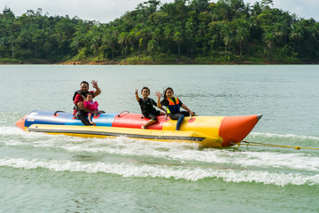 People enjoying water activities on banana boat at the Kenyir Lake, Terengganu, Malaysia.