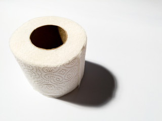 Close-up view of a new roll of toilet paper isolated on a white background, the concept of cleanliness and hygiene, household and toilet supplies, shortage due to the corona virus pandemic