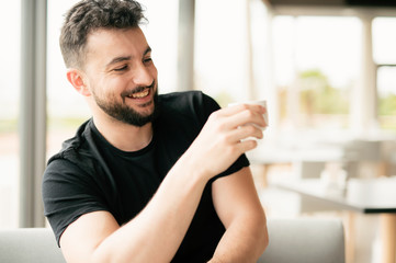 Bearded man drinking coffee in bar