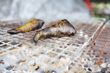 glutinous rice wrapping with banana leaves is grilling in the st