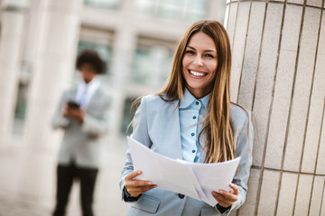 Fototapeta na wymiar Portrait of businesswoman smiling outdoor holding business documents