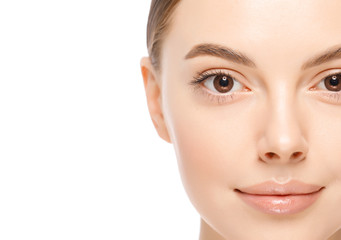 Fototapeta premium Horizontal headshot portrait of young brown-eyed female with glowing skin, isolated on white background, copy space on left. Beauty concept