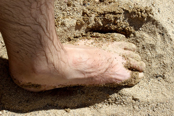 male feet on the beach