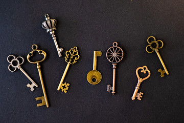 Many different old keys from different locks, scattered chaotically, flat lay.
