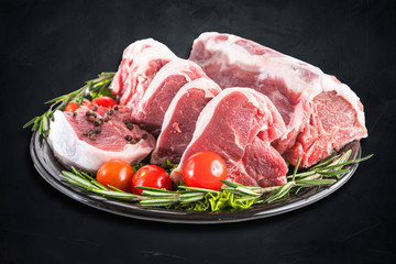 Fresh and raw meat. Whole piece of red meat ready to cook on the grill or BBQ . Background black blackboard