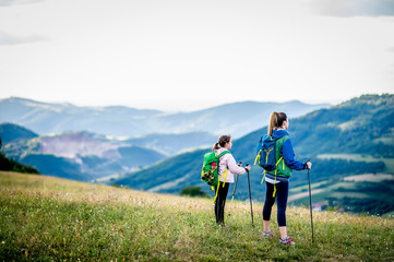 Young single mother hiking together with her daughter
