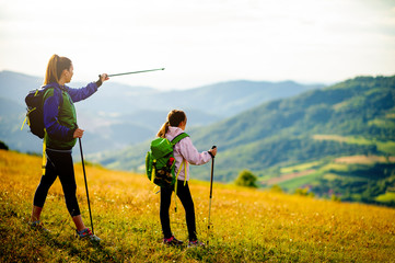 Young single mother hiking together with her daughter