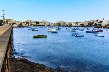 A view from the promenade of boats moored in the lagoon of Charco de San Gines in Arrecife, Lanzarote on a sunny afternoon