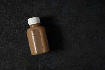 fresh coffee drink on a plastic bottle over dark background