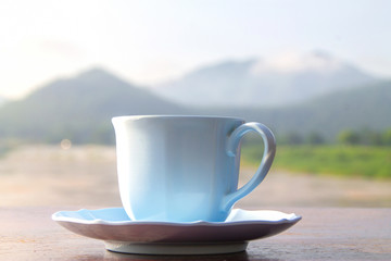 White coffee cup on mountain background in the morning near the river