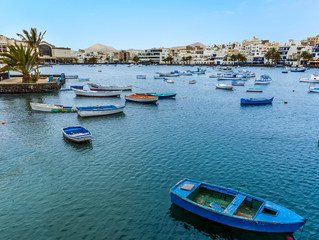 Fototapeta na wymiar A view across the boats moored in the lagoon of Charco de San Gines in Arrecife, Lanzarote on a sunny afternoon