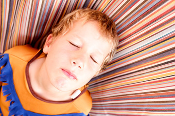 6 year old boy looking up with closed eyes dreaming.
