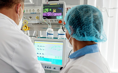 male doctor behind a monitor in intensive care