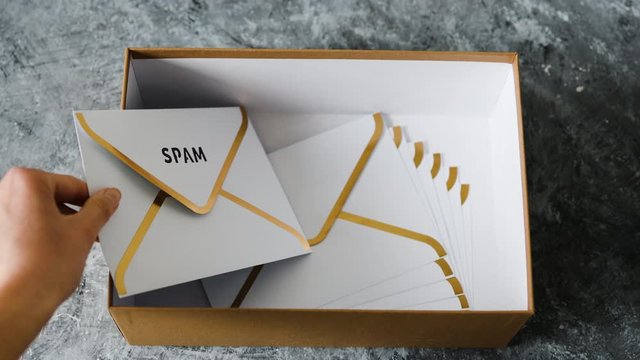 inbox organisation, group of envelopes inside box metaphor of email inbox and hand removing Spam from it