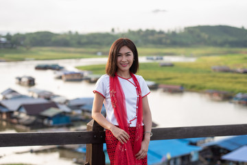 Obraz premium Young asian women traveler get dress traditional costume of Mon tribal at Mon village, Sangkhlaburi, Kanchanaburi, Thailand
